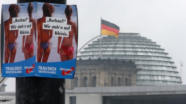 A poster of the nationalist Alternative for Germany, AfD, reading "Burka? We prefer bikinis" hangs on a lamp post in from of the Reichstag building Berlin, Germany.