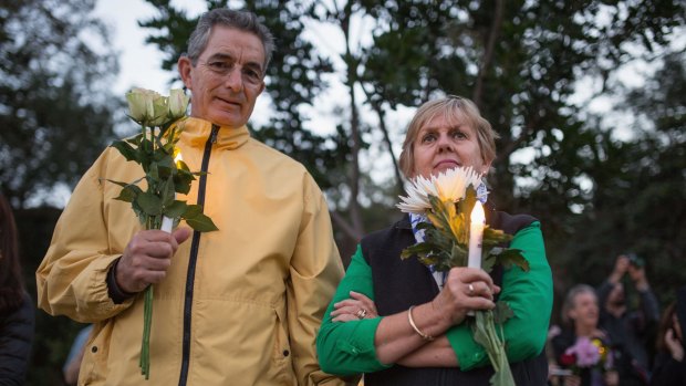 Prayers for condemned pari: A couple holds candle and flowers as part of an Amnesty international vigil for the Bali 9 duo.