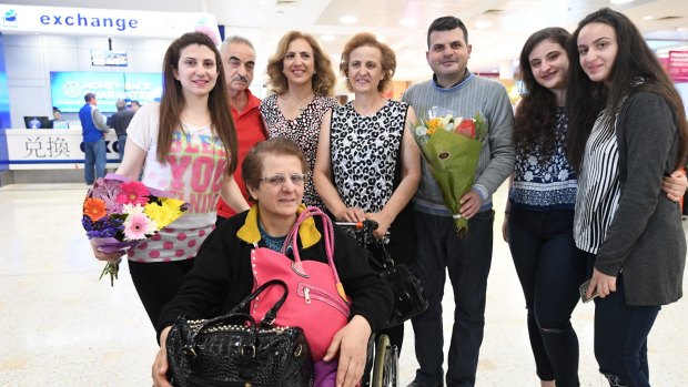 Raghida Salibi, 64, (in the wheelchair) and her two adult children, son Wessam Ozon, 38, (holding flowers) and daughter Razan Ozon, 29, are among the newest refugees to arrive in Australia. 