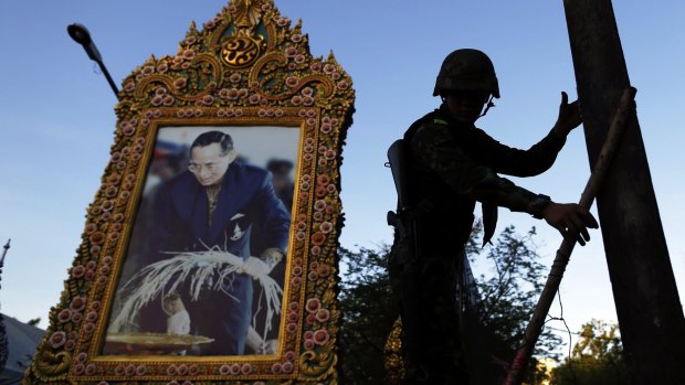 A soldier in front of a picture of Thailand's King Bhumibol Adulyadej amid anti-government protests in central Bangkok in May.