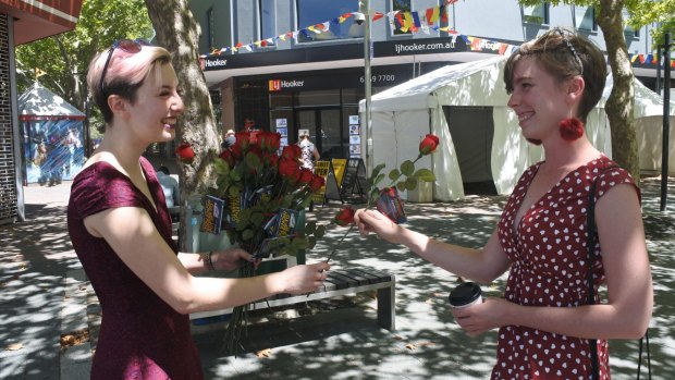 Pi Lee from Sexual Health and Family Planning gives a rose to Emily Bugden in Civic on Valentine's Day.