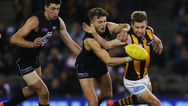 Hawthorn's Sam Mitchell battles with Carlton's Patrick Cripps for the ball.