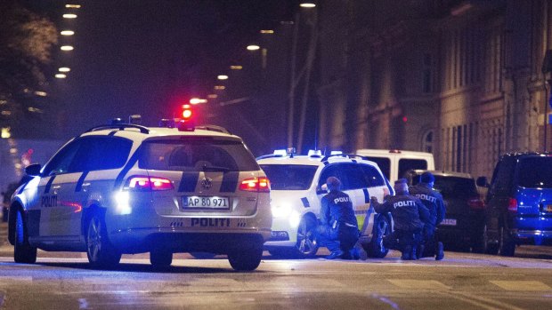 Police take cover in a street in central Copenhagen early on Sunday morning following a fatal shooting at a synagogue in Krystalgade, central Copenhagen.