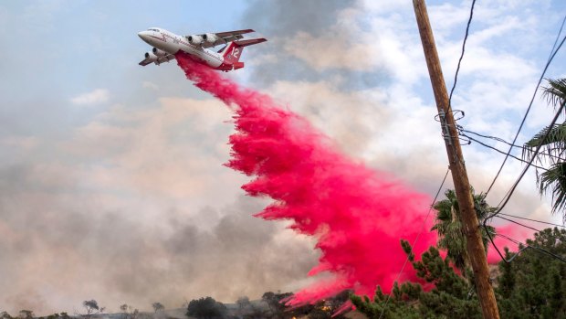 A plane makes a drop on a hillside in Sun Valley neighborhood, north of Los Angeles on Saturday