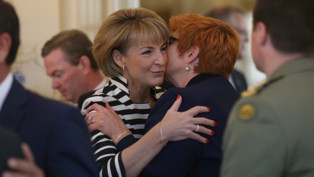 Senator Marise Payne is embraced by Senator Michaelia Cash before the ministry swearing in ceremony at Government House on Monday.