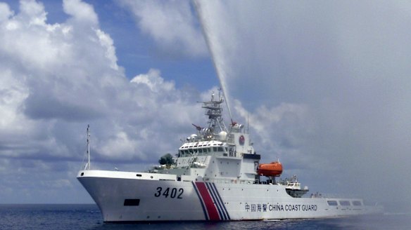 A Chinese Coast Guard boat sprays a water cannon at Filipino fishermen near Scarborough Shoal in the South China Sea last year.