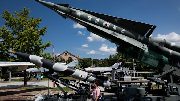 A visitor takes photographs next to a mock MIM 14 Nike Hercules surface-to-air missile, right, and other missiles on display at the War Memorial of Korea museum in Seoul, South Korea.