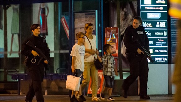 Police officers escort people out of the Olympia Einkaufzentrum shopping mall in Munich on Friday.