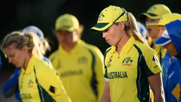 Down and out: Australia captain Meg Lanning (right) and her team come to terms with defeat in the World Cup semi-final.