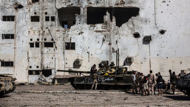 Fighters affiliated to the Tripoli government rest and reload weapons during an offensive against IS militants in Sirt, Libya.