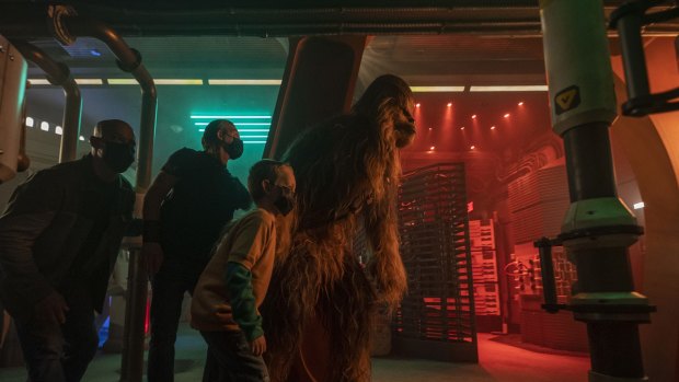 Chewbacca leads passengers through the Halcyon starcruiser Engineering Room.