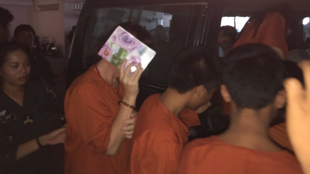 Tammy Davis-Charles hides her face as she is led back to her jail cell from the court in Phnom Penh in May.