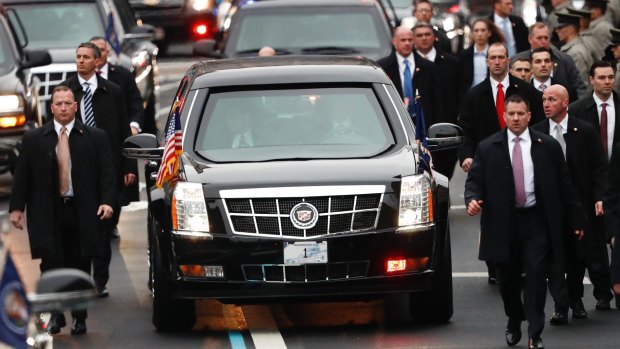 Members of President Donald Trump's Secret Service detail walk with the first family's motorcade vehicle along the Inauguration Day Parade Route in Washington on January 20.
