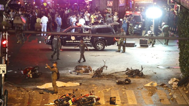 A policeman photographs debris after the August 17, 2015, explosion in central Bangkok.