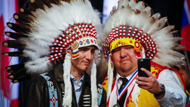 Canadian Prime Minister Justin Trudeau, left, poses for a selfie with an elder after receiving a ceremonial headdress while visiting the Tsuutina First Nation near Calgary, Alberta, last week.