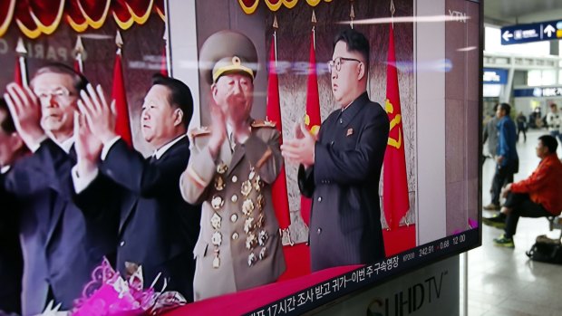 A television news program shows North Korean leader Kim Jong-un, right, applauding during a parade to celebrate the congress of the ruling Workers' Party.