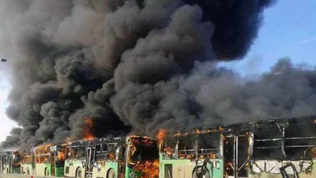Smoke rises from green government buses awaiting to evacuate residents in Idlib province, Syria on Sunday.