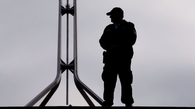 An Australian Federal Police officer guards the ministerial entrance to Parliament House in Canberra.