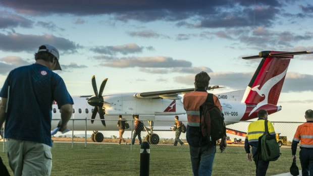 Off to work: FIFO workers head for a plane at Moranbah airport.