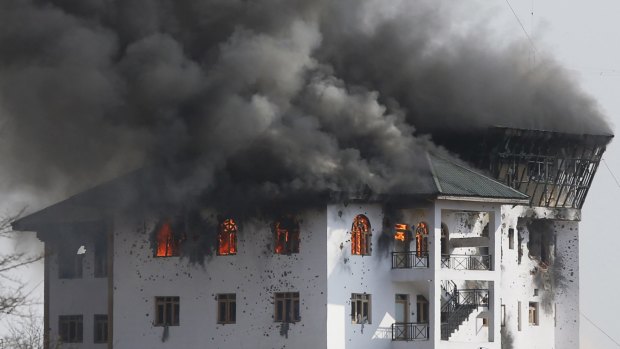 Smoke billows from a building in Pampore, near Srinagar, in Indian-controlled Kashmir on Monday. Militants took refuge in the training institute when a gun battle ensued.