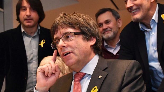 Ousted Catalan leader Carles Puigdemont gestures as he watches the election results in Brussels.