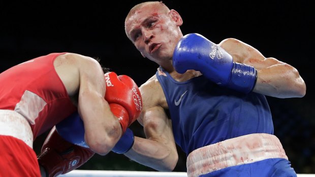 Russia's Vladimir Nikitin, right, is bloodied and bruised during his fight with Michael Conlan.