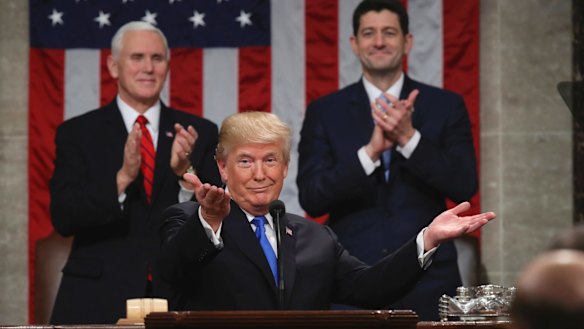 President Donald Trump gestures as Vice President Mike Pence and House Speaker Paul Ryan applaud.
