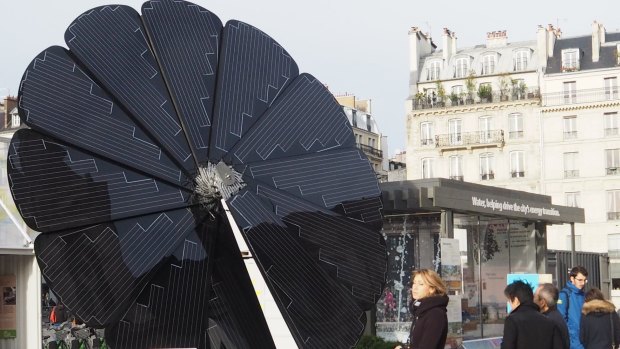Parisians take in the renewable energy offerings of the future, including this solar 'smartflower' that opens as the sun rises and follows it through the day.