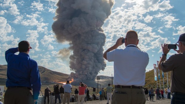 Spectators watch the second and final qualification motor test for the Space Launch System's booster.