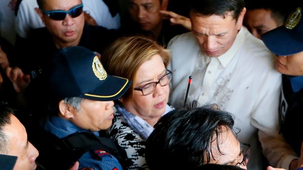 Philippine opposition Senator Leila de Lima, center, is escorted to her detention on Friday, a day after a warrant for her arrest was issued.