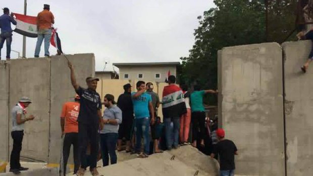 Supporters of Shiite cleric Muqtada al-Sadr storm the blast walls surrounding Baghdad's highly fortified Green Zone.