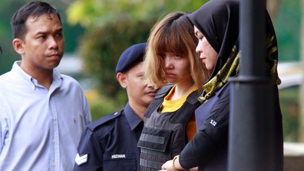 Vietnamese murder suspect Doan Thi Huong, second from right, is escorted by police officers out of court on Wednesday.