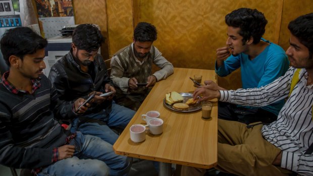 Kashmiri students browse the internet on their mobile phones at a restaurant in Srinagar, Indian-controlled Kashmir, on Wednesday.