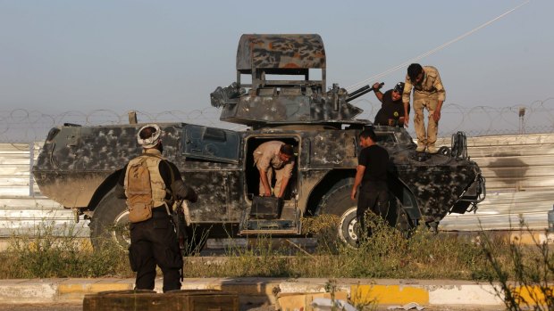 Members of the Iraqi Shi'ite militant group called Imam Ali Brigades prepare their armoured vehicle at the front line with Islamic State in Tikrit.