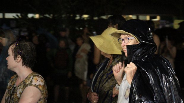 Crowds try to find shelter from the downpour at the Woodford Folk Festival.