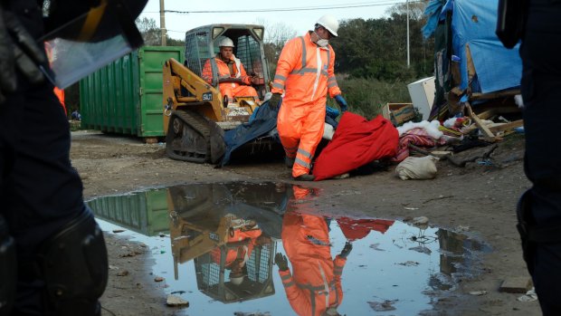 Crews demolish makeshift shelters at the Calais camp.