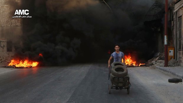 A photo from the Syrian anti-government  group Aleppo Media Centre (AMC) shows a young man burning tyres in an attempt to prevent airstrikes above Aleppo in recent days.