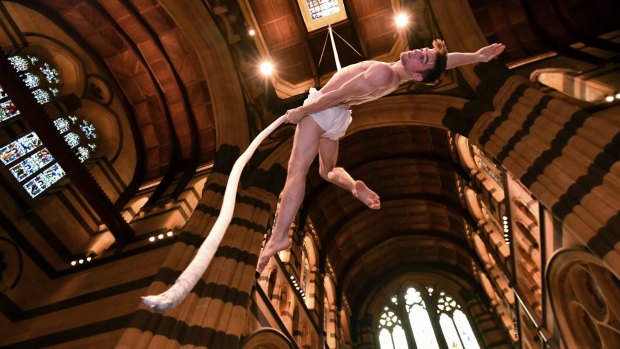 Aerial artist Tim Rutty suspended from the ceiling of St Paul's Cathedral.
