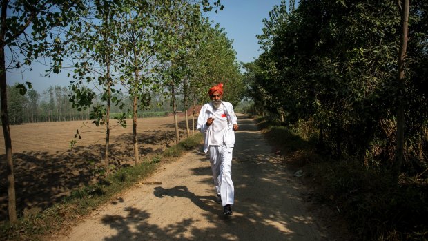 Dharam Pal Singh, a herder who regularly runs and claims to be 119 years old, trains on a dirt road near his home in the village of Gudha, India, Oct. 27, 2016. 