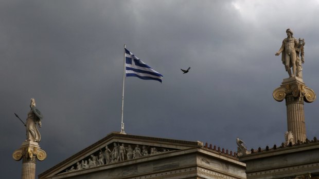 Dark clouds hover: A Greek flag flutters in Athens.