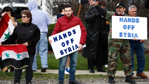 People hold signs during a rally in opposition to the US airstrikes in Syria in Allentown, Pennsylvania. Allentown has one of the US's largest Syrian populations, mostly Christian and in support of Syrian President Bashar al-Assad.