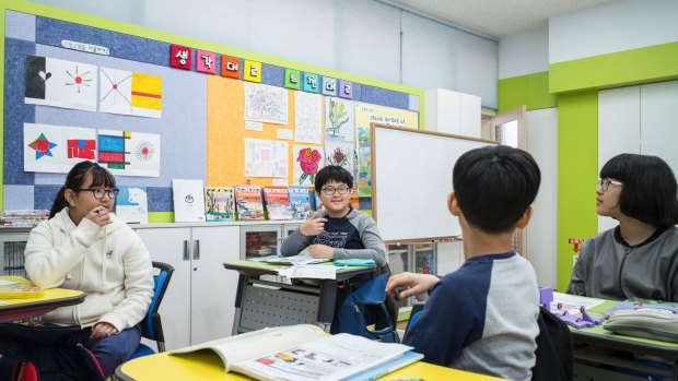 Kim So-jin, right, and her twin brother Kim Jun-yong, centre, in their sixth grade class of four in Taesung.