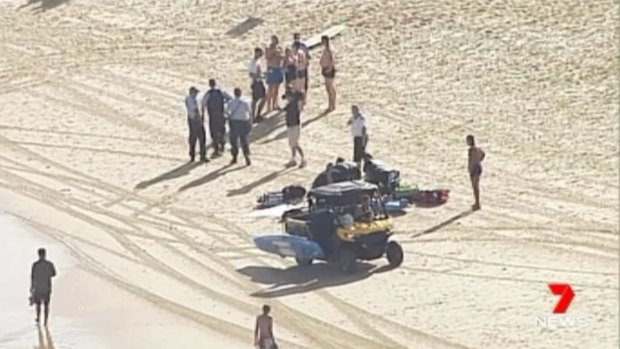 Emergency services treat one of the swimmers pulled from the water.