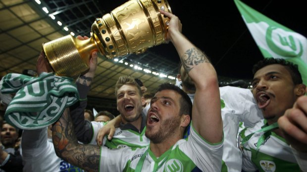 VfL Wolfsburg's Ivan Perisic holds up the trophy.