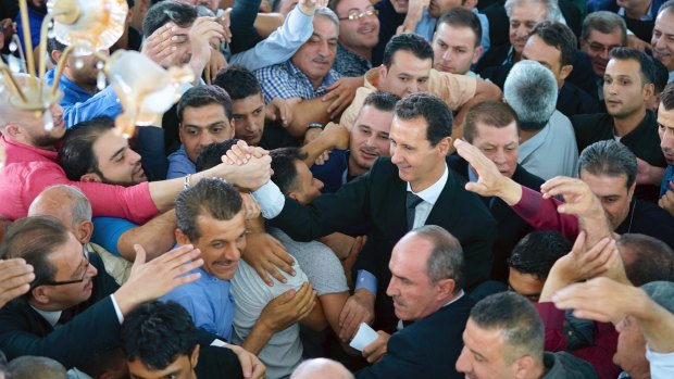 Syrian President Bashar Assad, centre, greeting people following the prayers of the first day of Eid al-Adha on September 1.