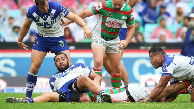 Crunched: Rabbitohs rake Issac Luke is smashed as he crosses the line by Bulldogs prop Sam Kasiano.