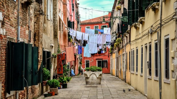 Clothes hanging across buildings on a narrow alley in Venice.