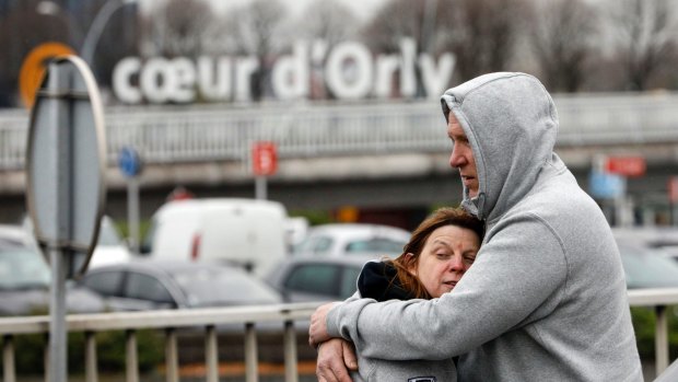 Travellers hug outside Orly airport after one of its two terminals was evacuated on Saturday. 