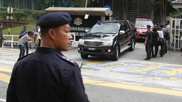 Police cars carrying Doan Thi Huong and Siti Aisyah, the two women accused in the assassination of Kim Jong-nam, leave court.