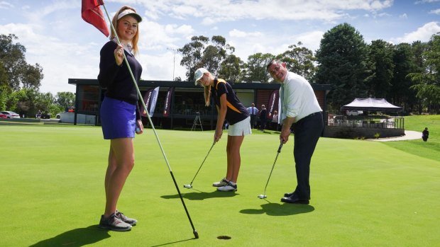 Member for Monaro and Deputy Premier of NSW, John Barilaro, tests his putting skill against sisters Chloe, (on the left holding flag) and Amber Thornton after announcing Queanbeyan GC will host the 2019 Women's NSW Open. 